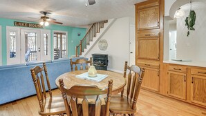 A dining area with a wooden table and chairs, a ceiling fan, and a staircase leading to another level. - Fish & Swim Off the Dock: Lake Sinclair Family Gem (Eatonton)