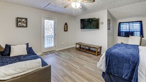 A bedroom with a bed, a sofa, a ceiling fan, and a wooden bench. - Fish & Swim Off the Dock: Lake Sinclair Family Gem (Eatonton)