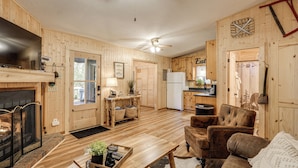 Ein gemütliches Blockhaus-Interieur mit Kamin, Holzmöbeln und Küchenzeile.