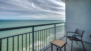 A balcony with a view of the ocean, a chair, and a small table. - Sky-High Oceanfront Retreat – 21st-Floor Penthouse (Myrtle Beach)