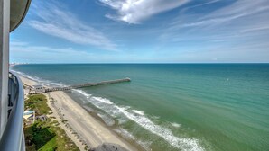 A coastal view with a pier extending into the sea, a beach, and a clear sky. - Sky-High Oceanfront Retreat – 21st-Floor Penthouse (Myrtle Beach)