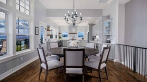 A dining area with a round table, chairs, and a chandelier. - The Quandary Vineyards Estate (Yamhill)