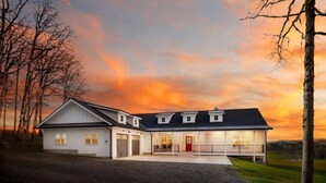 A two-story house with a garage, a covered porch, and a driveway. - The Quandary Vineyards Estate (Yamhill)