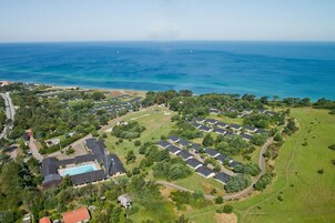 Vista aérea de una zona residencial con casas, una piscina y vistas al océano.