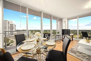 Uma sala de jantar com vista para a cidade, grandes janelas e móveis modernos.