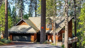 A cabin with a garage, a deck, and a large tree in front. - Game Room & Hot Tub! Dog-Friendly Arnold Retreat (Arnold)