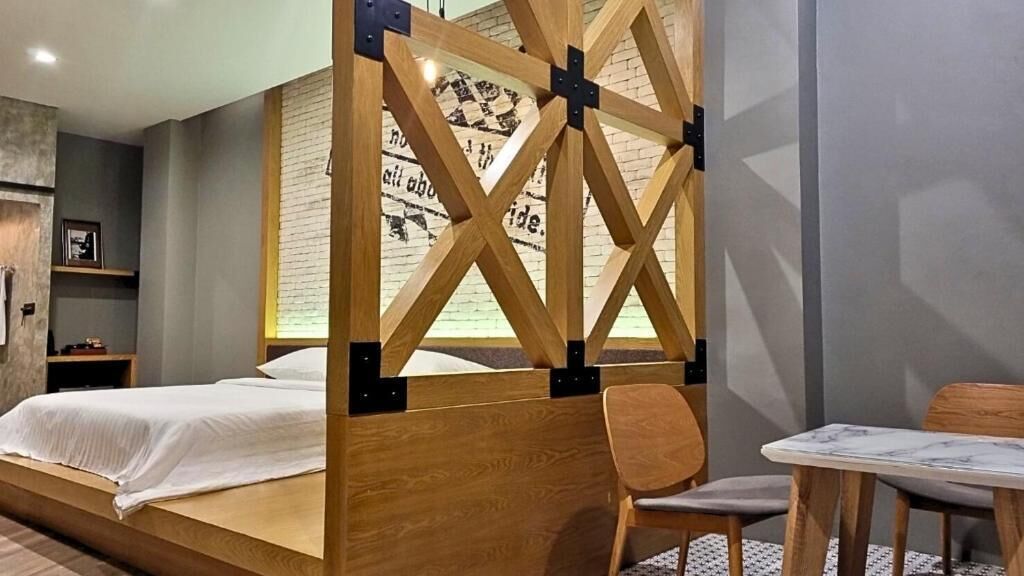 A modern bedroom with a wooden bed frame, a small bedside table, and a chair.