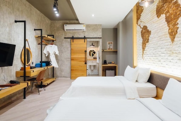 Una habitación de hotel moderna con una cama grande, un escritorio, un televisor y un mapa mundial en la pared.