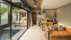 Un intérieur moderne avec une piscine à débordement, un coin salon confortable et une cuisine.