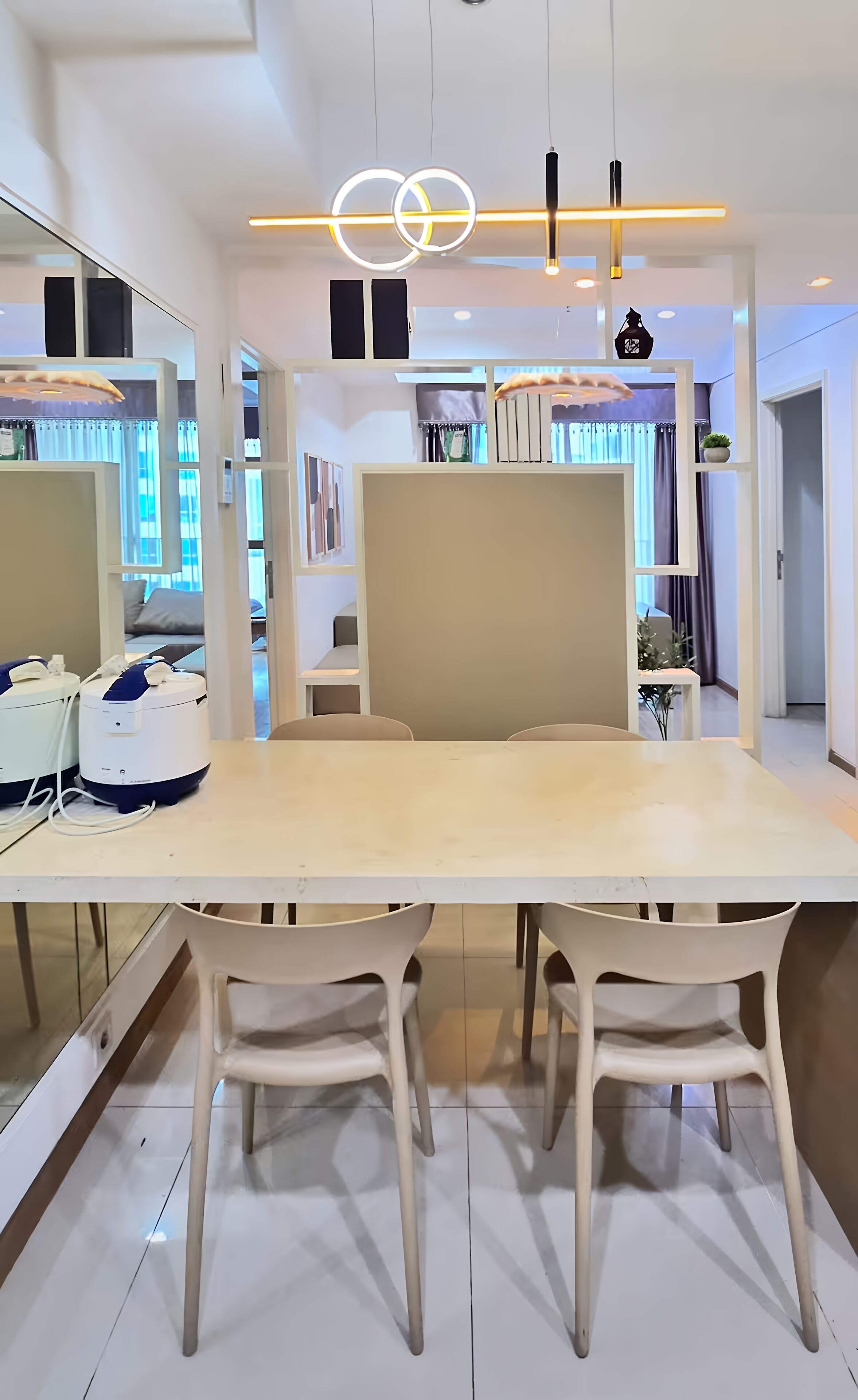 A modern dining area with a large table, two chairs, and a mirror.