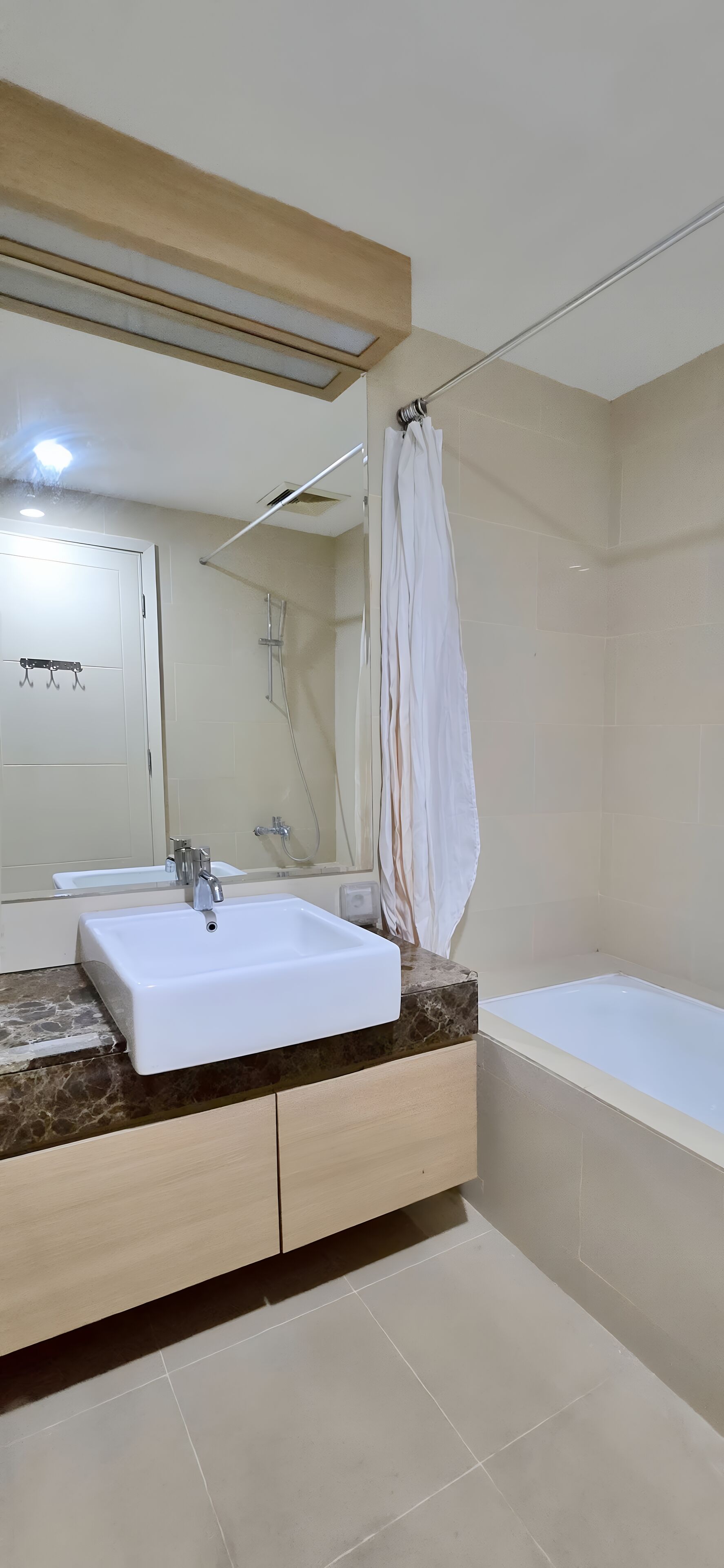 A bathroom with a white sink, a bathtub, and a shower curtain.