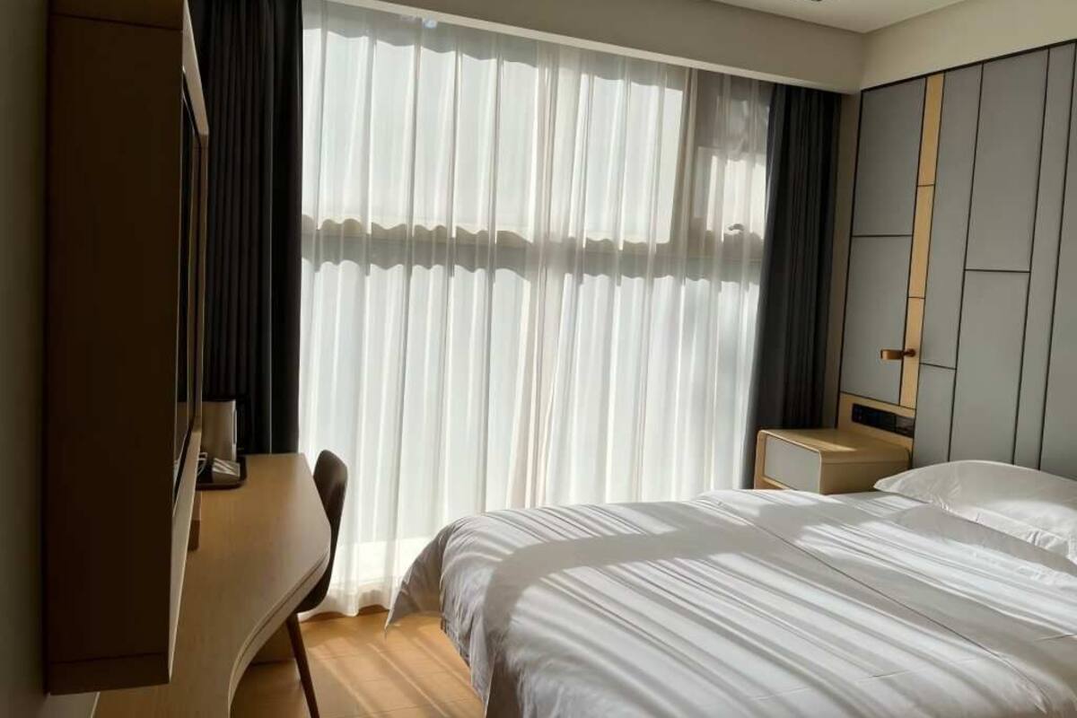Una habitación de hotel con cama, escritorio y armario.