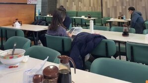 A restaurant with green seating, a menu board, and a sign indicating a 100% satisfaction guarantee. - Vienna Classic Hotel (Beijing)