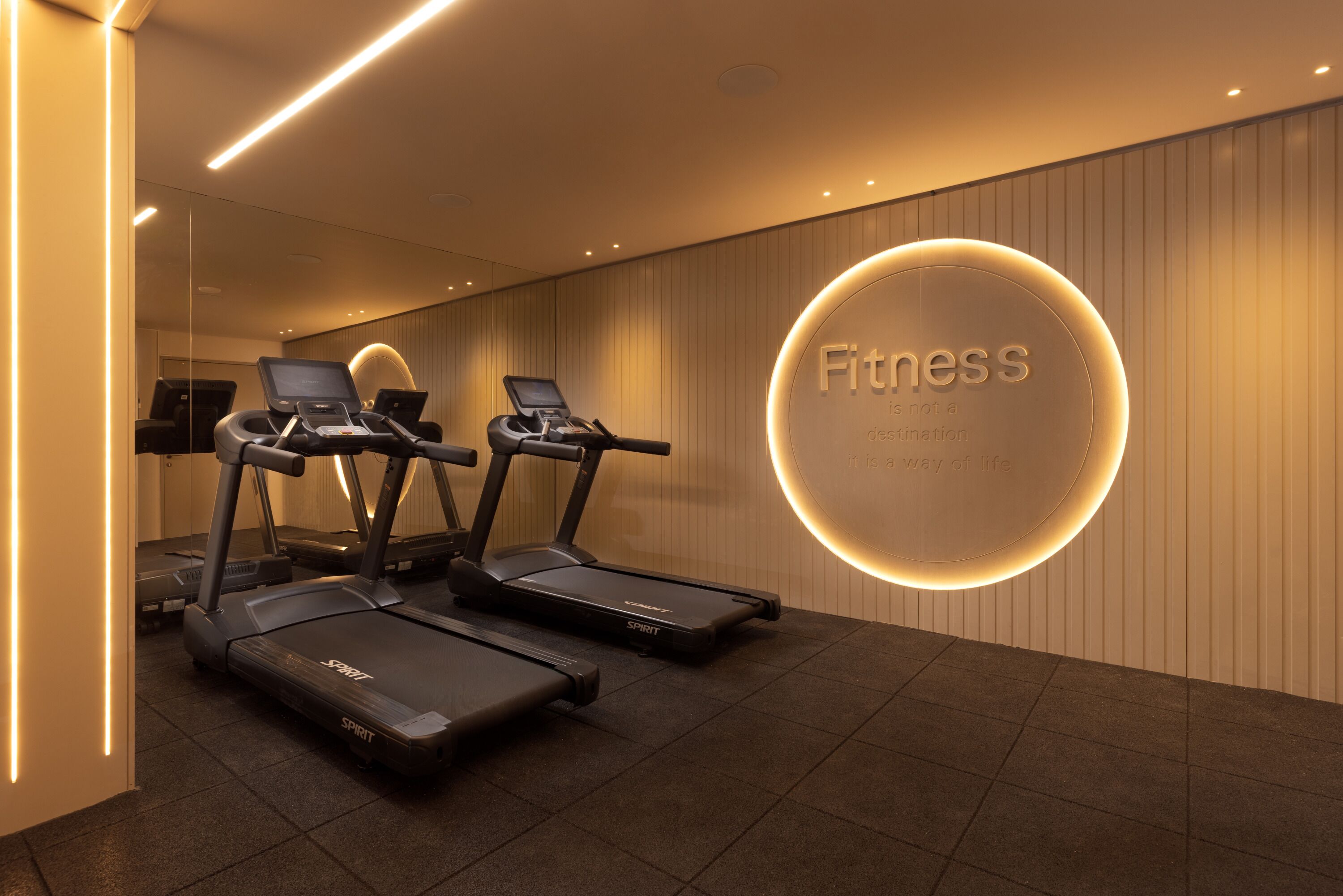A modern fitness center with treadmills and a motivational wall.