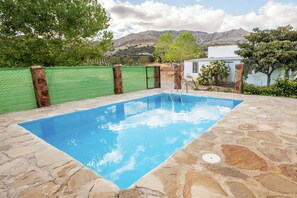 A rectangular swimming pool with a stone deck, surrounded by a green fence and trees. - Mansion with private pool in Natural Park (Priego de Cordoba)