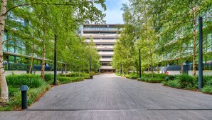 A modern building with a central courtyard, surrounded by trees and greenery. - Premium Apartment with Scenic Views near City (Campbell)