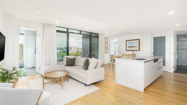 A modern living room with a sofa, a coffee table, and a kitchen area with a dining table and chairs. - Premium Apartment with Scenic Views near City (Campbell)