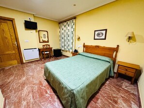 A hotel room with a bed, a desk, a chair, a television, and a window with curtains. - Single Room Albohera Playa Hotel (San Javier)
