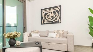 Un salon moderne avec un canapé, une table basse et une œuvre d’art abstraite accrochée au mur.
