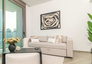 Ein modernes Wohnzimmer mit einer Couch, einem Couchtisch und einem an der Wand befestigten abstrakten Kunstwerk.