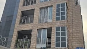 Ein mehrstöckiges Gebäude mit modernem architektonischen Design, mit Balkonen und großen Fenstern.