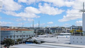Una azotea con vistas despejadas del paisaje urbano, que incluye edificios modernos y un puerto deportivo.