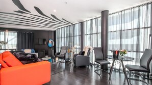 Una sala moderna con un ventanal grande, un sofá y una mesa de centro.