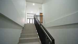 Una escalera con barandilla negra que lleva a un piso superior.