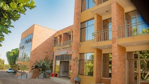 Um edifício moderno com área de recepção, várias varandas e fachada de tijolos.