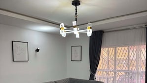 A modern living room with a grey sectional sofa, a black coffee table, and a patterned rug. - Fidrock Hotel And Suites (Owerri)