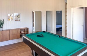A pool table in a room with wooden flooring, a cabinet, and a door leading to another room. - Gorgeous home in Børkop with sauna (Børkop)
