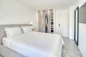 A bedroom with a large bed, a walk-in closet, and a door leading to another room. - A/C 2bdr/6P flat just two minutes from the beach! (Antibes)
