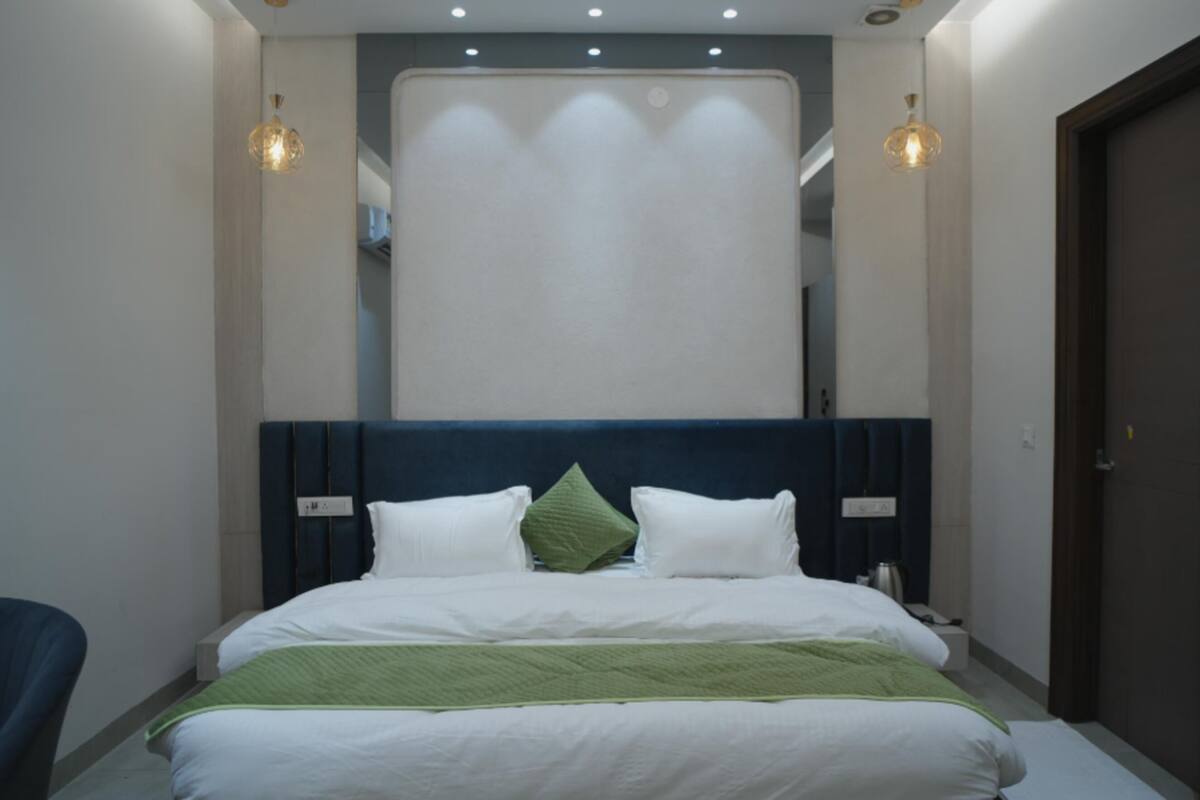 Una habitación de hotel moderna con una cama grande, una silla y una puerta.