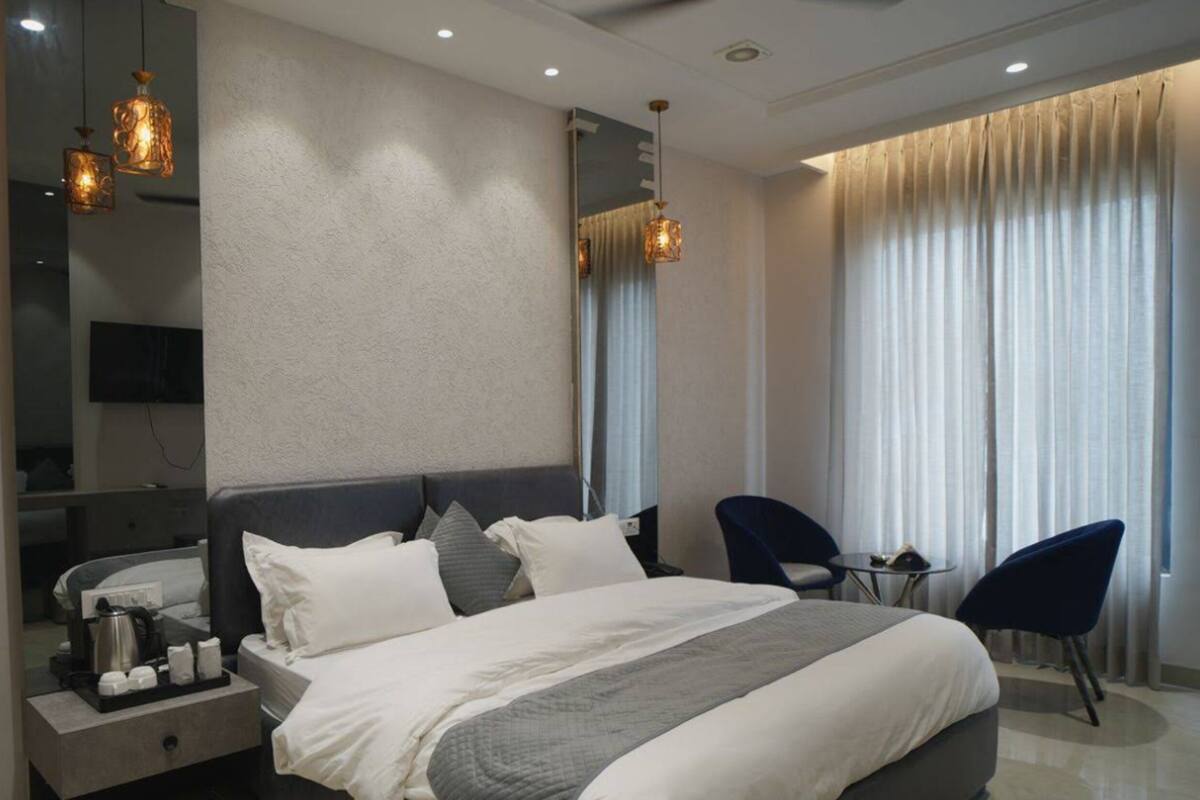 Una habitación de hotel moderna con una cama grande, mesitas de noche, un escritorio y una silla.