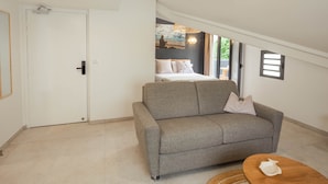 Ein modernes Wohnzimmer mit grauem Sofa, einem Holztisch und einer Pendelleuchte.