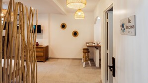 Um corredor com estrutura decorativa de madeira, luminária no teto, televisão fixada na parede e uma placa indicando 'The Intense Apt 5'.
