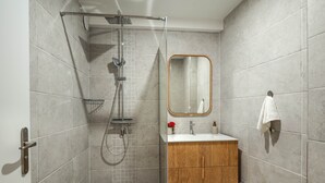 A modern bathroom with a shower, sink, and vanity. - Appt Endémik - L'Escale Bleue Saint-Leu, Reunion Island (Saint-Leu)