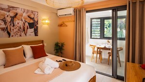 A hotel room with a bed, a dining area, and a view of greenery. - Appt Belle Dame - L'Escale Bleue Saint-Leu, Réunion (Saint-Leu)