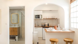 Una cucina moderna con un'isola centrale, due sgabelli e lampade a sospensione.