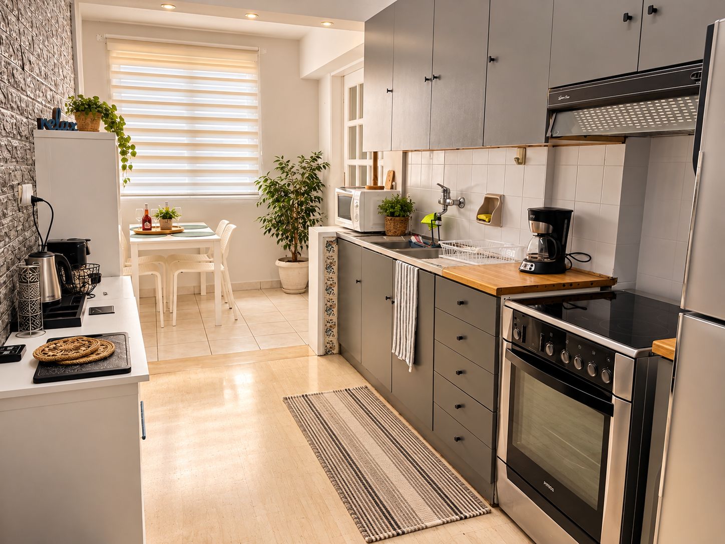 Une cuisine moderne avec des meubles gris, une cuisinière noire et un plan de travail en bois.