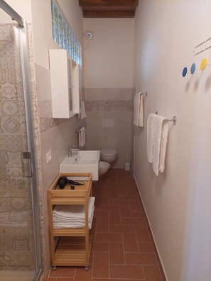 Een douche, een haardroger, een bidet, handdoeken