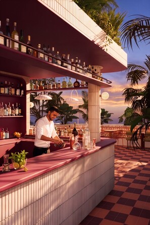 A bar area with a bartender, shelves of liquor bottles, and a checkered floor. - The Standard Lisbon (Lisbon)