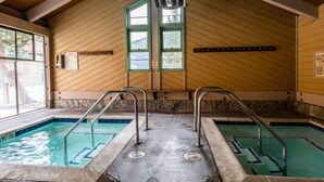 An indoor swimming pool with two lanes, metal ladders, and a wooden ceiling. - Mammoth Creek Unit 31 (Mammoth Lakes)