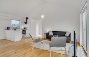 Um apartamento moderno com cozinha, sala de estar e varanda.