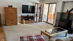 Una sala de estar acogedora con una televisión de pantalla plana, un mueble de madera y una chimenea.