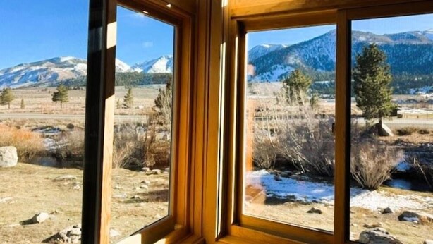 A room with large windows offering a view of a mountainous landscape. - Mammoth Creek Unit 32 (Mammoth Lakes)