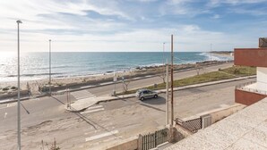 A coastal road with a pedestrian crossing, a parked car, and a building with a view of the beach and ocean. - La Torre by Interhome (Ugento)