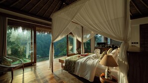 A bedroom with a canopy bed, a view of the outdoors, a wooden floor, and a bedside table with a lamp. - Marangga ubud valley view & private pool (Ubud)
