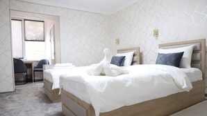 Een hotelkamer met een groot bed, een bureau en een stoel.