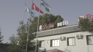 Een hotel met een bord waarop 'Lu Vita Hotel' staat en verschillende vlaggen.